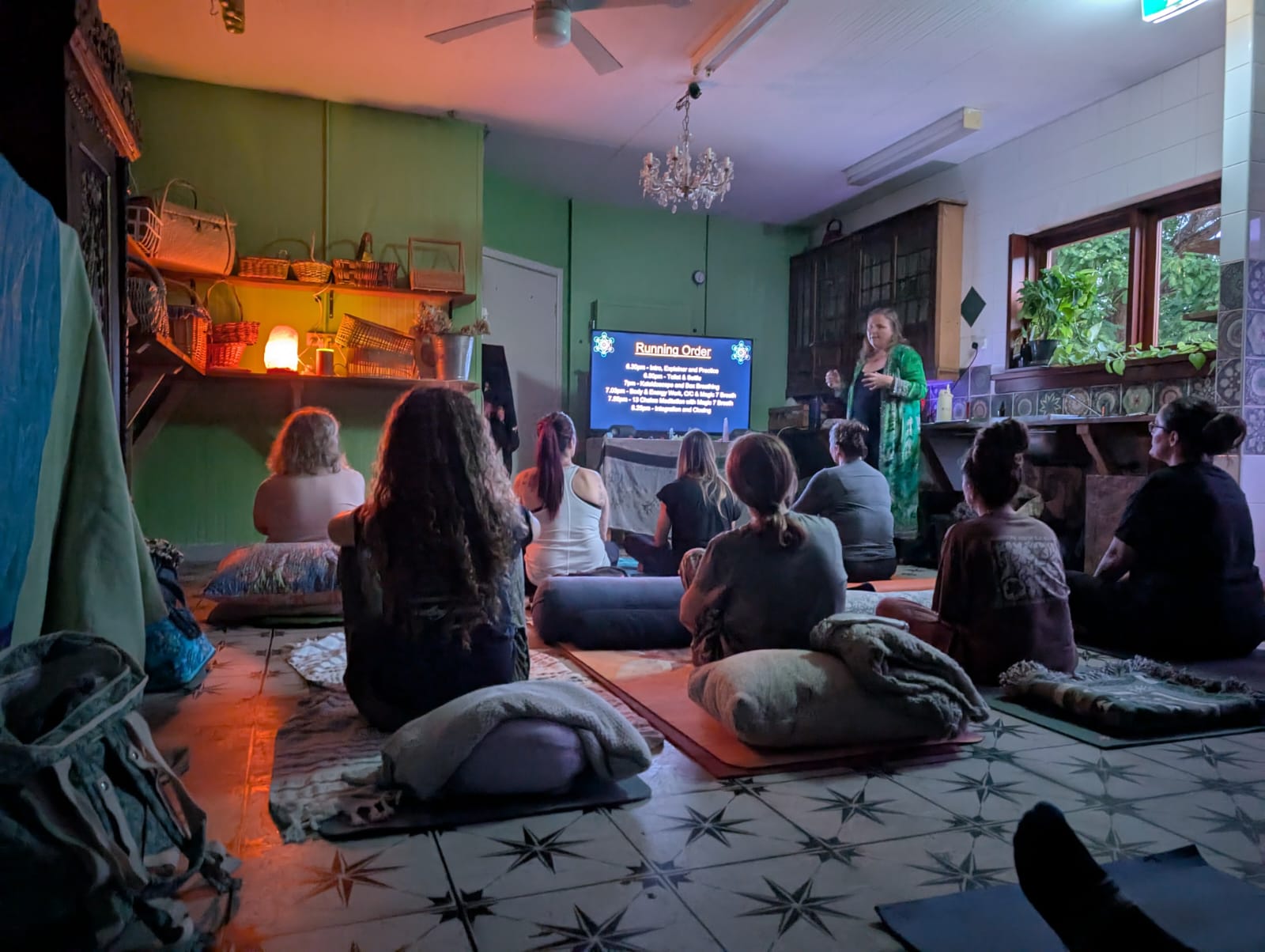 Nyaree facilitating a live sound session with participants on mats