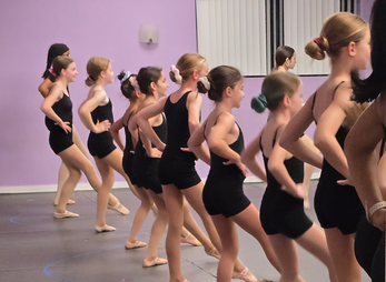 Dancers working through combinations at the barre in class