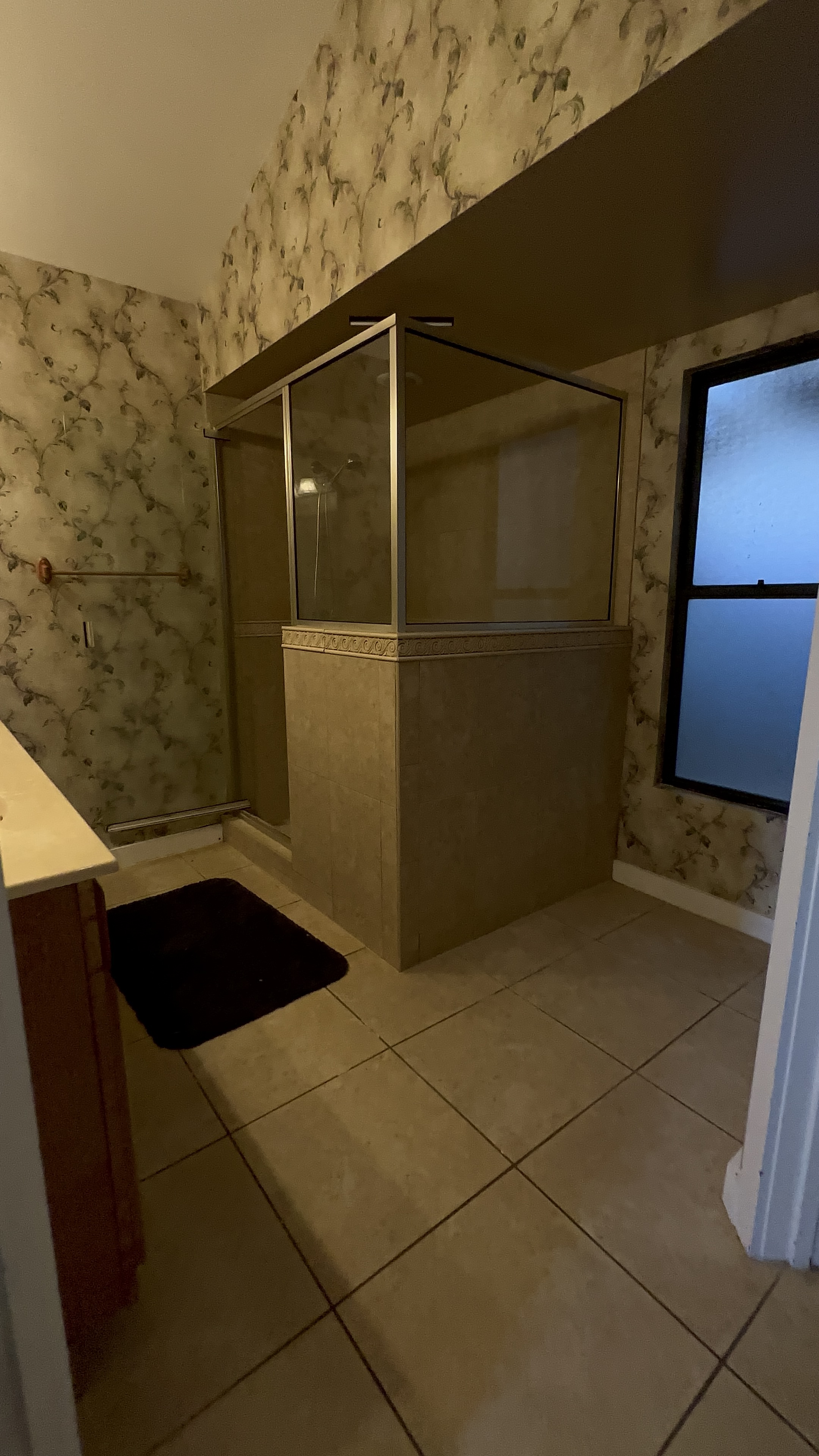 Dated bathroom with floral wallpaper before tile remodel Seminole County FL - Protocol Home Services