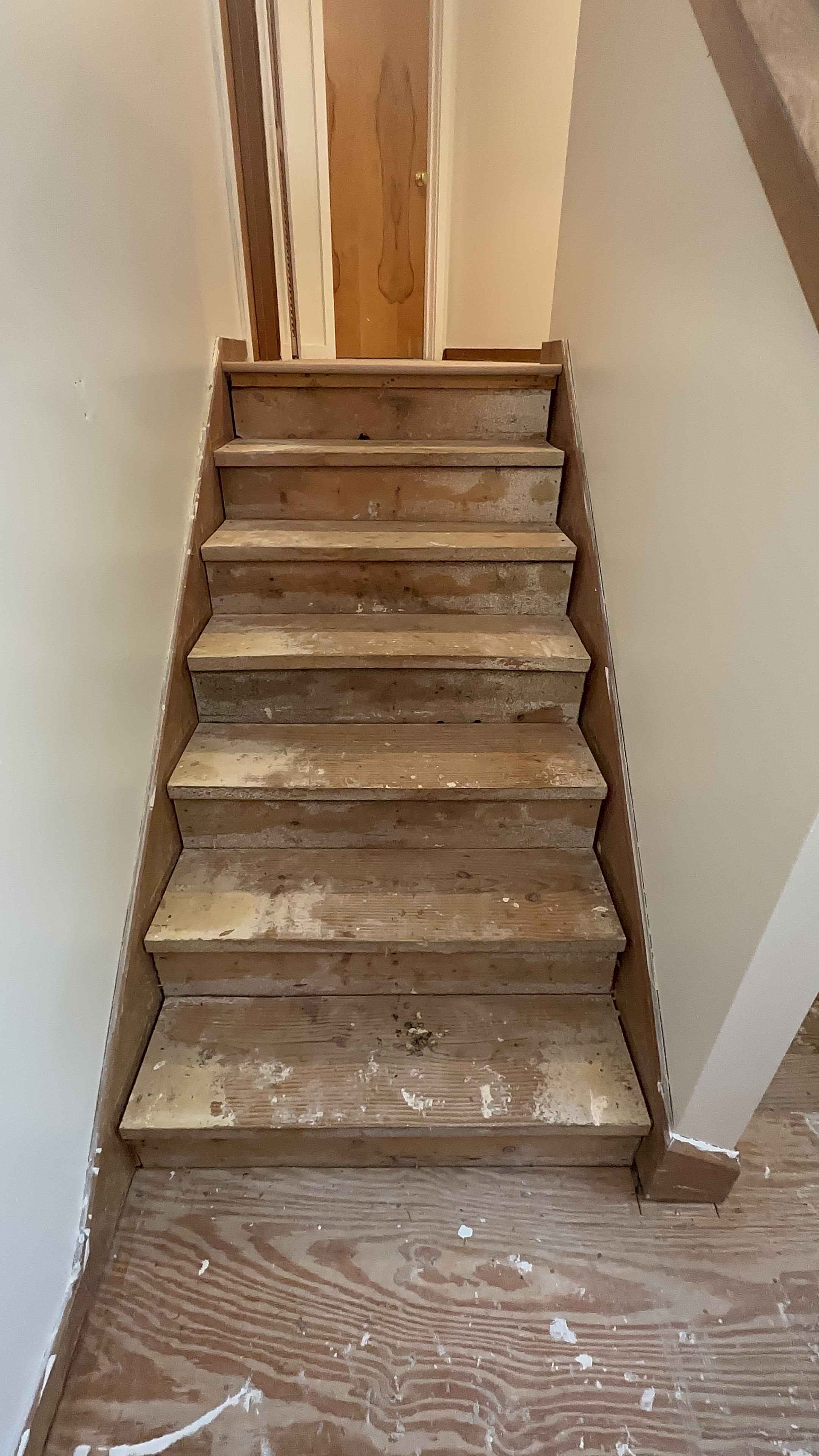 Worn raw wood staircase before LVP stair wrap installation Seminole County FL - Protocol Home Services