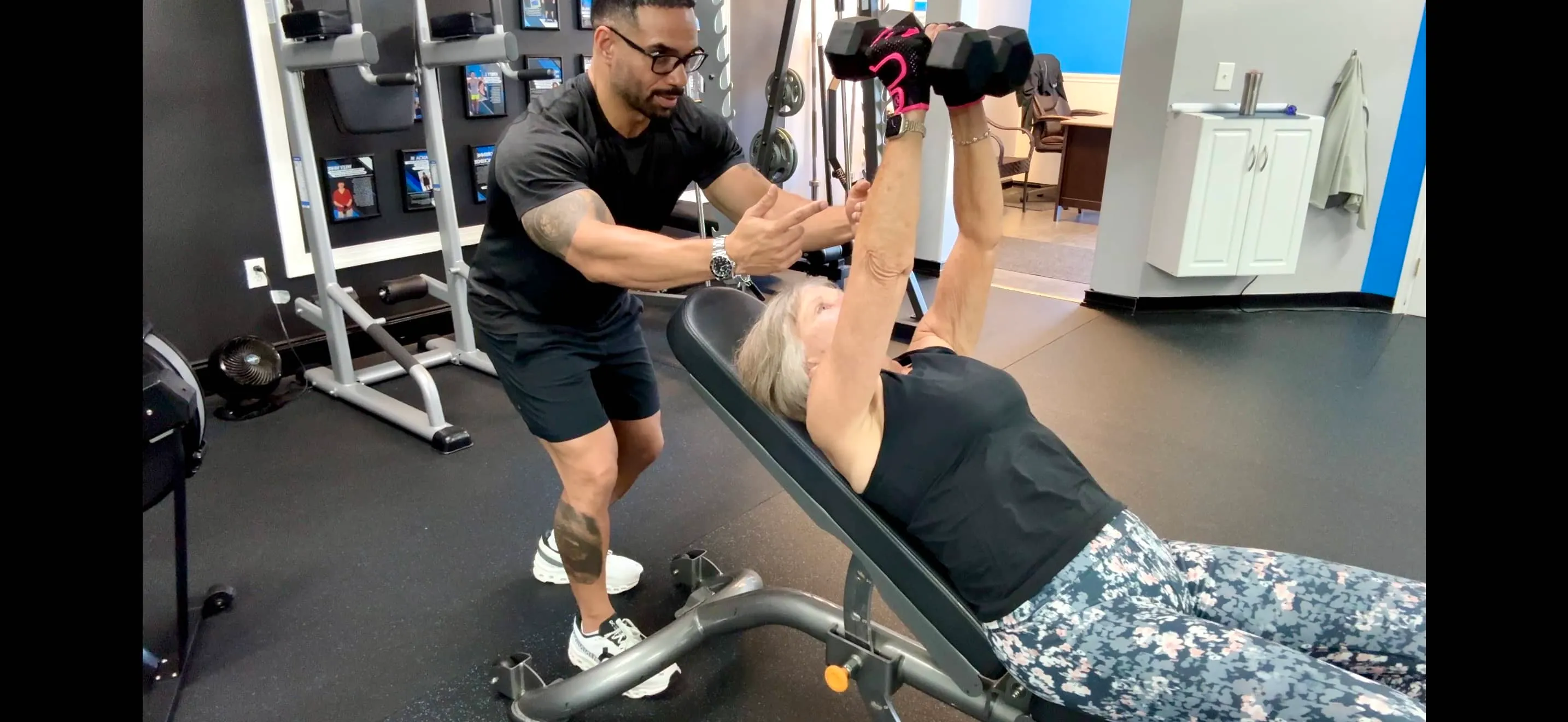 Coach CC Matthews coaching an older adult client through strength and balance exercises in the private Trinity Fitness personal training studio on Burns Road in Palm Beach Gardens