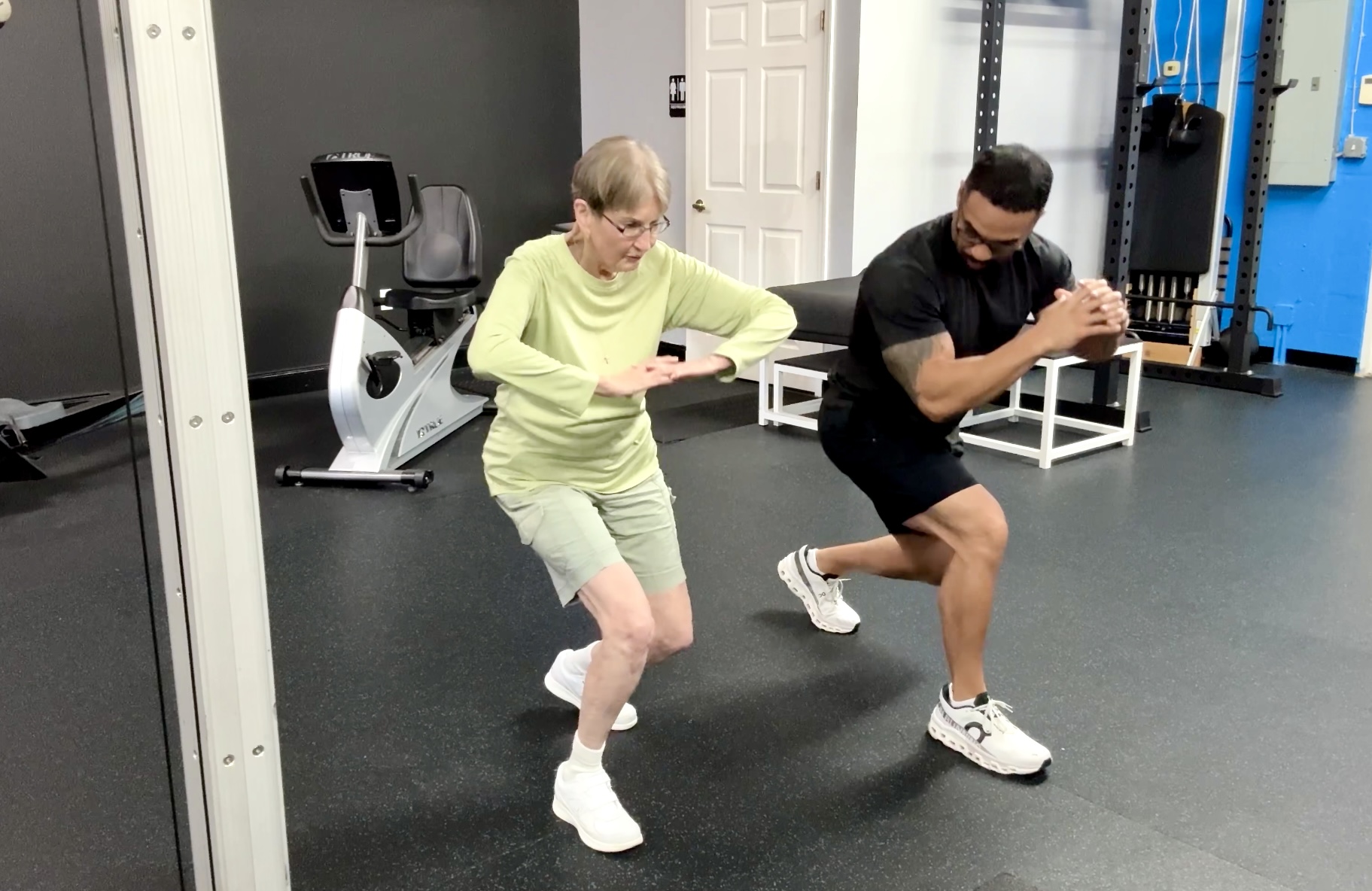 Coach CC Matthews leading a semi-private personal training session with two adult clients training side by side in the private Trinity Fitness studio on Burns Road in Palm Beach Gardens