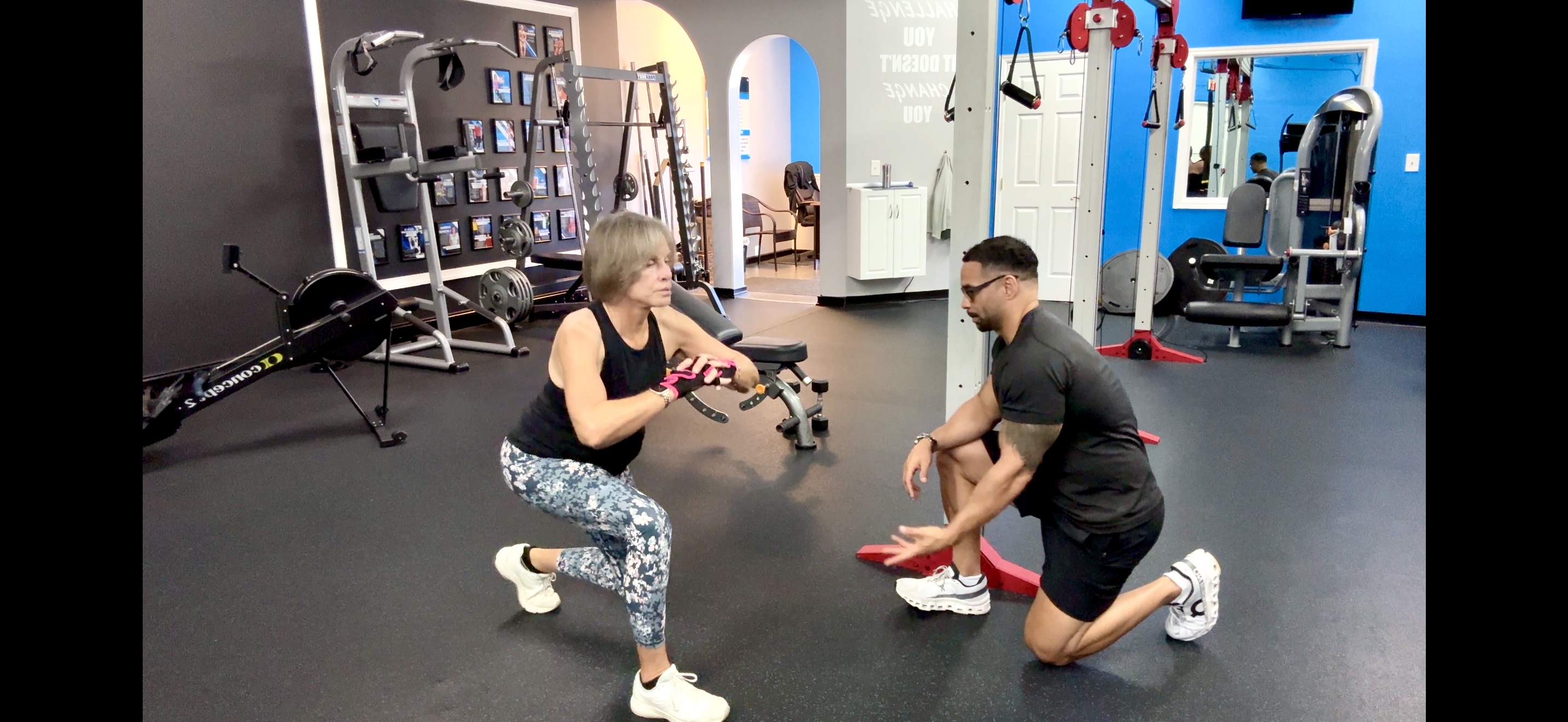 Coach CC Matthews coaching a senior client on squat form inside the Palm Beach Gardens studio