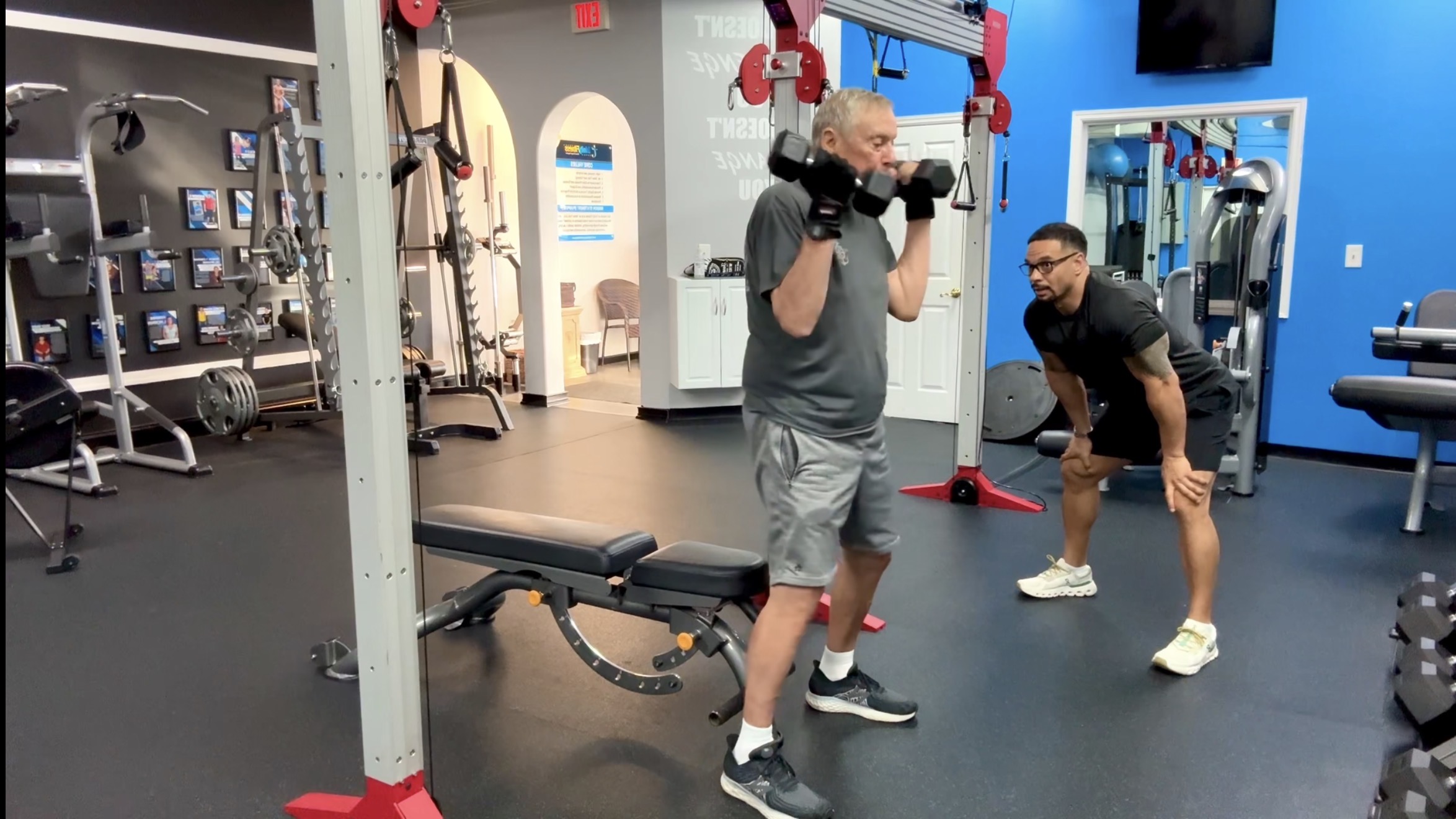 Coach CC Matthews coaching an older adult client on movement and balance in the Palm Beach Gardens studio