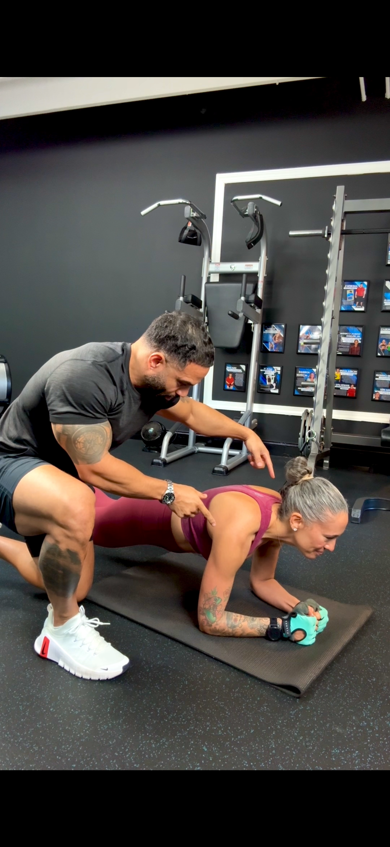 A personal trainer guiding a client through an exercise inside a private fitness studio