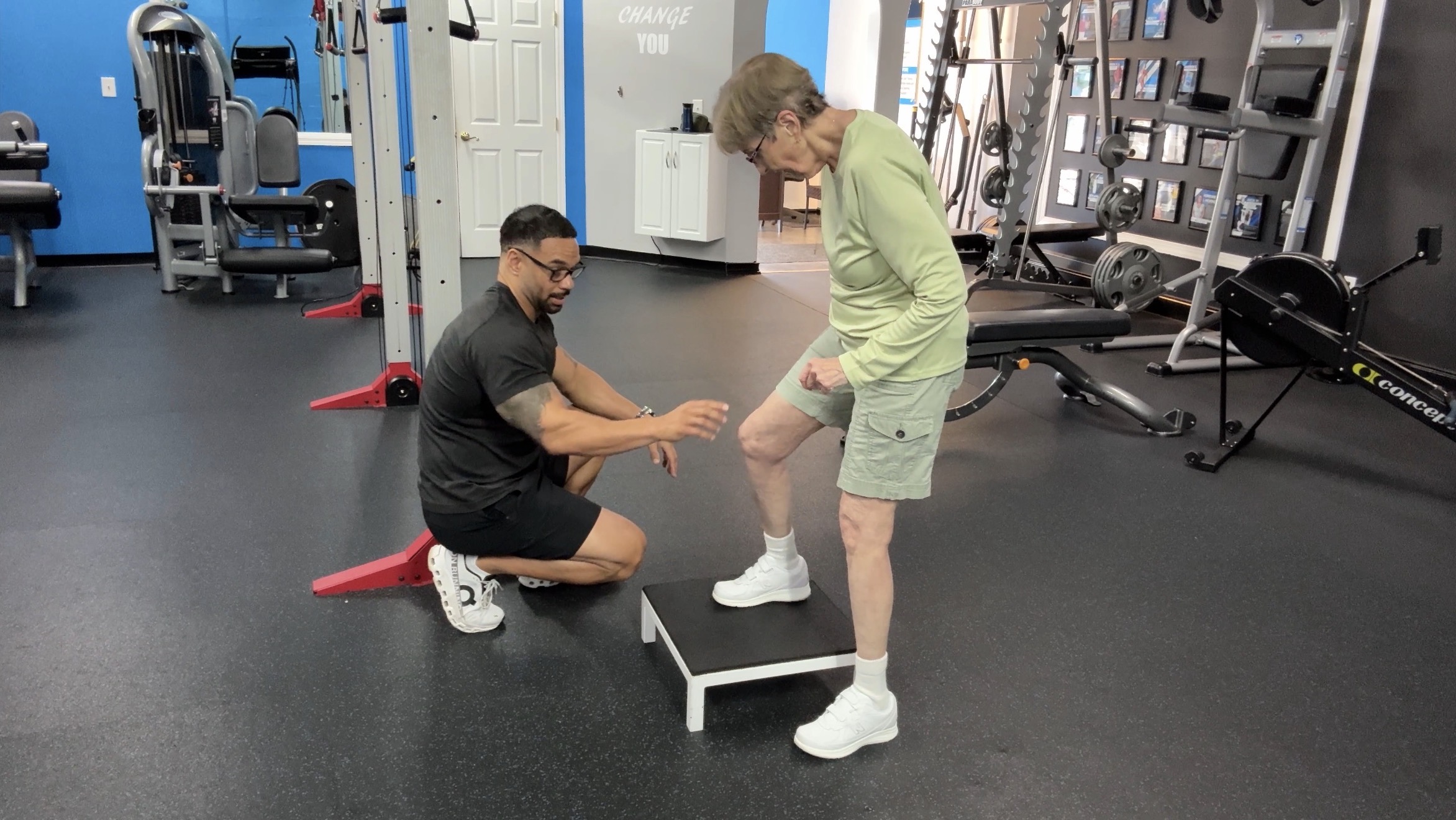 Coach CC working one-on-one with a client stepping onto a platform in the studio
