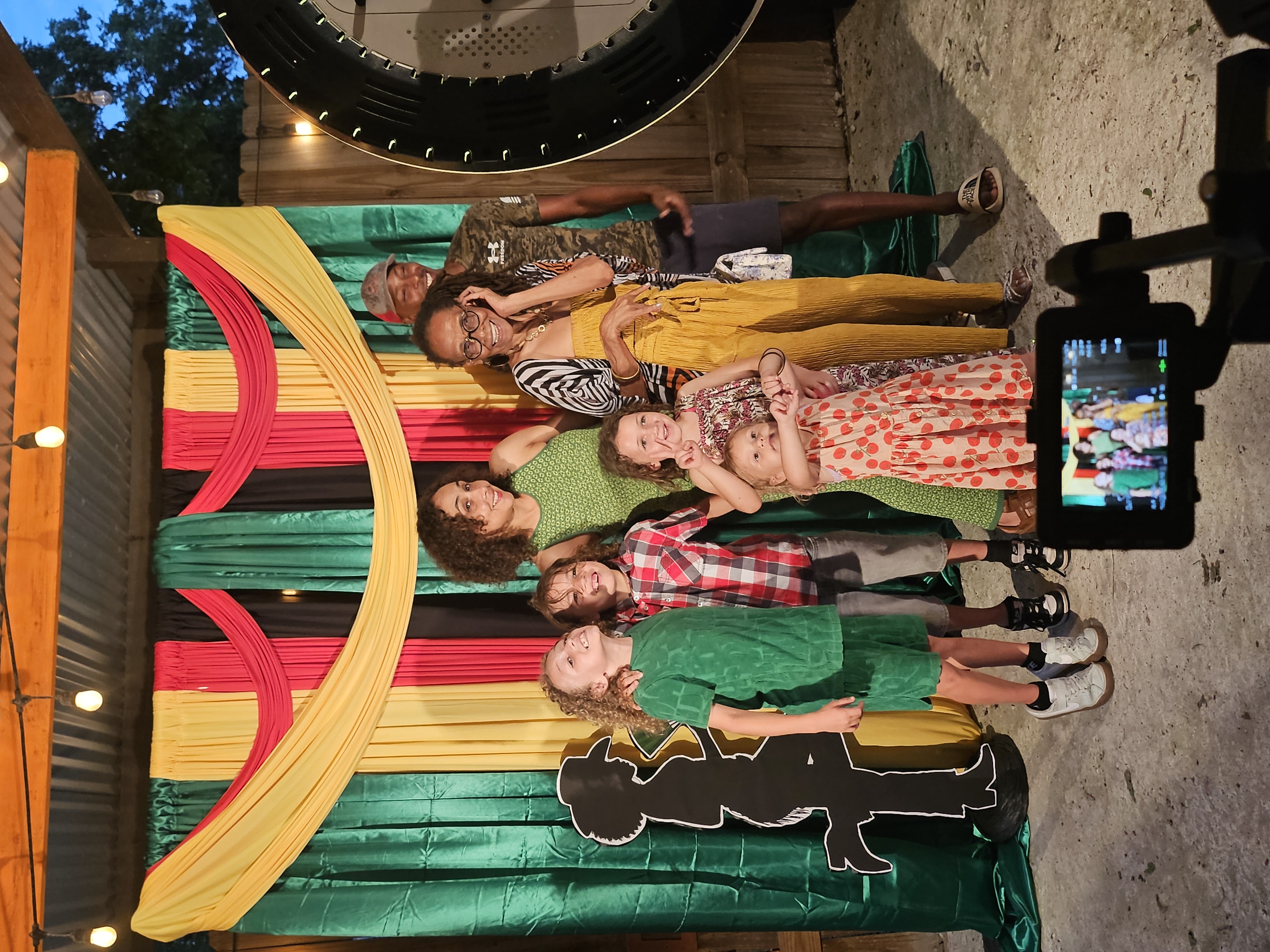 Group photo taken at a photo booth backdrop during a Central Texas event
