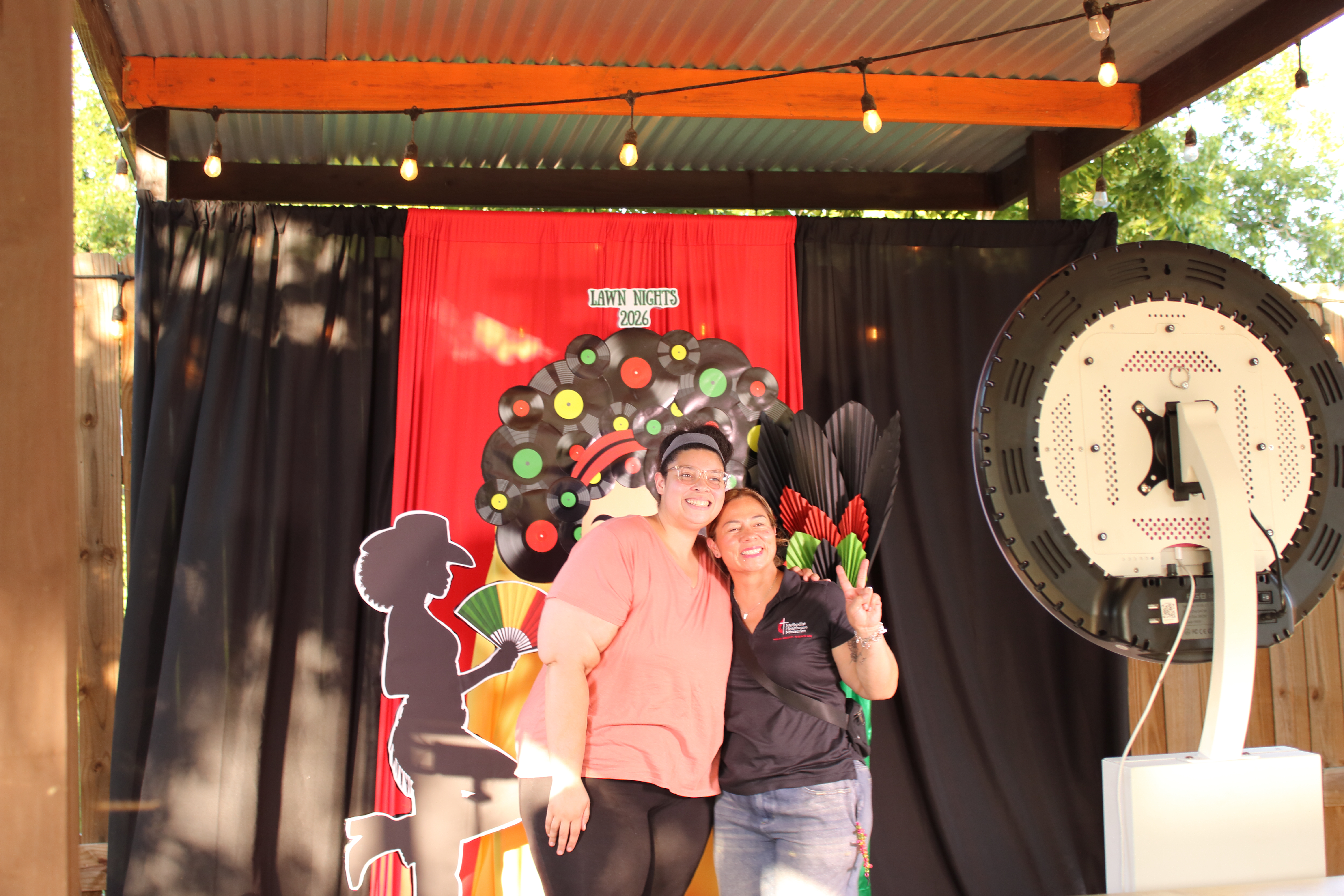 Outdoor photo booth setup with a red curtain backdrop at a Central Texas venue