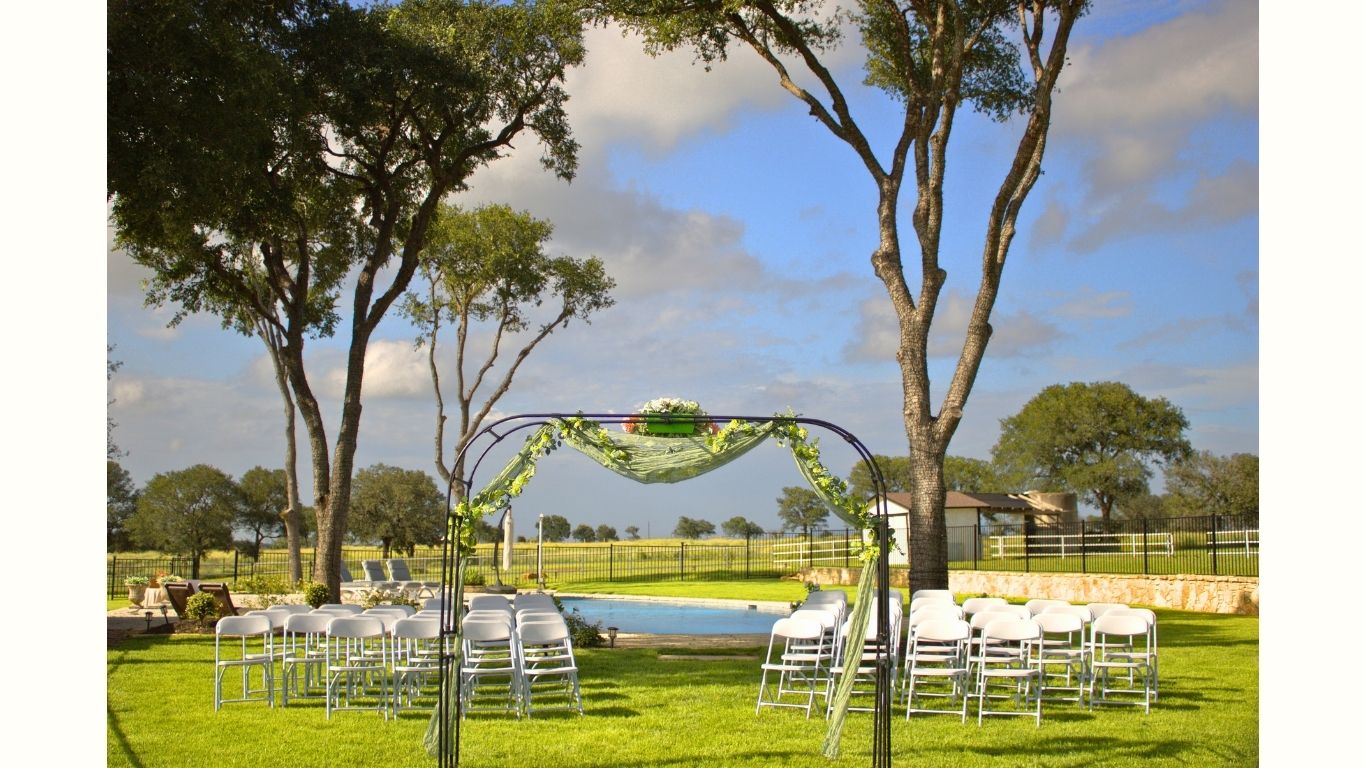 Outdoor wedding ceremony setup with floral arch and seating at a Central Texas venue