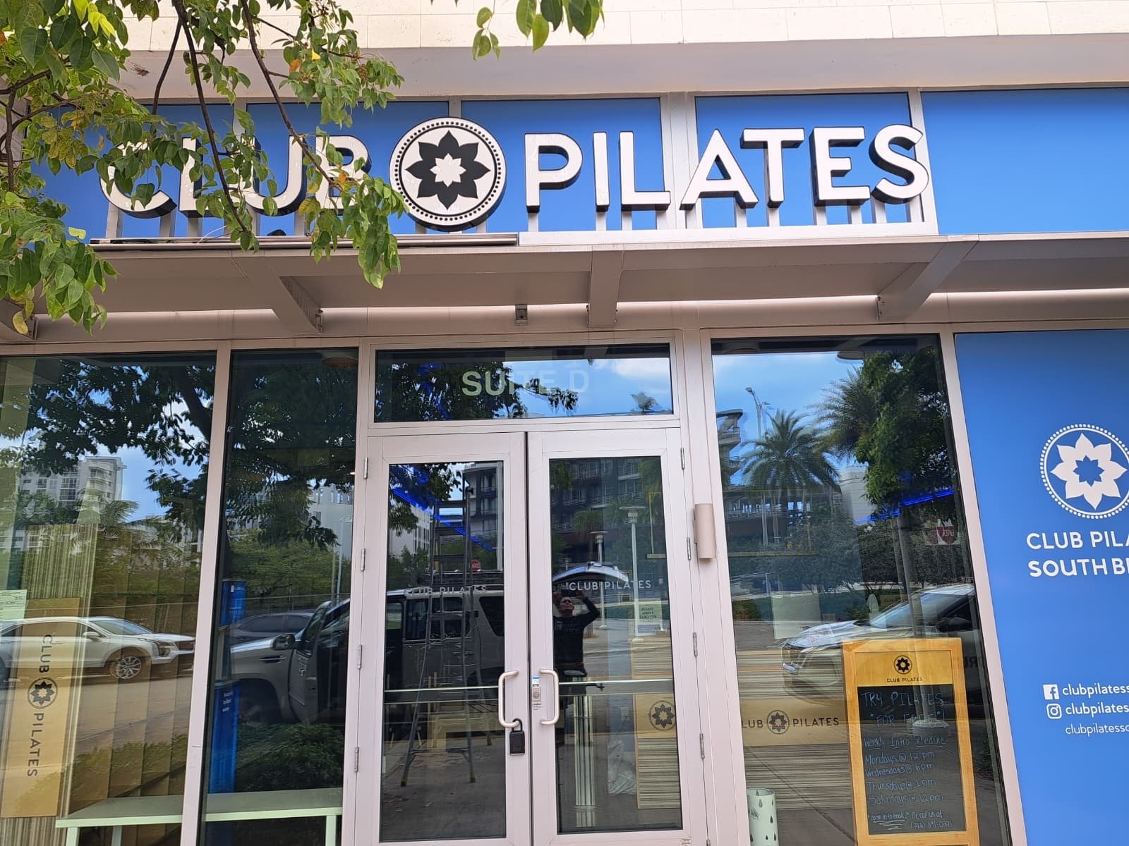 Illuminated channel letters and blade sign on a fitness studio storefront in Miami Beach