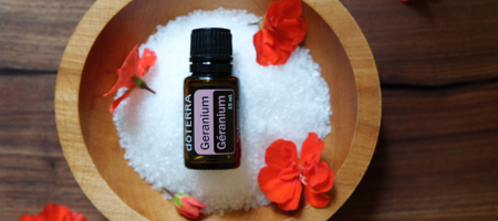 bottle of geranium essential oil sitting in a bowl of Epsom salts bottle of geranium essential oil sitting in a bowl of Epsom salts