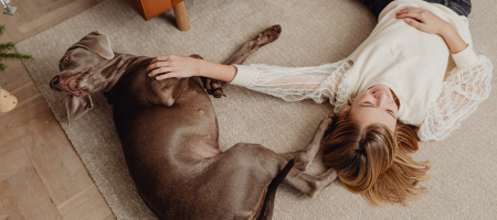 girl and her dog laying on the carpet
