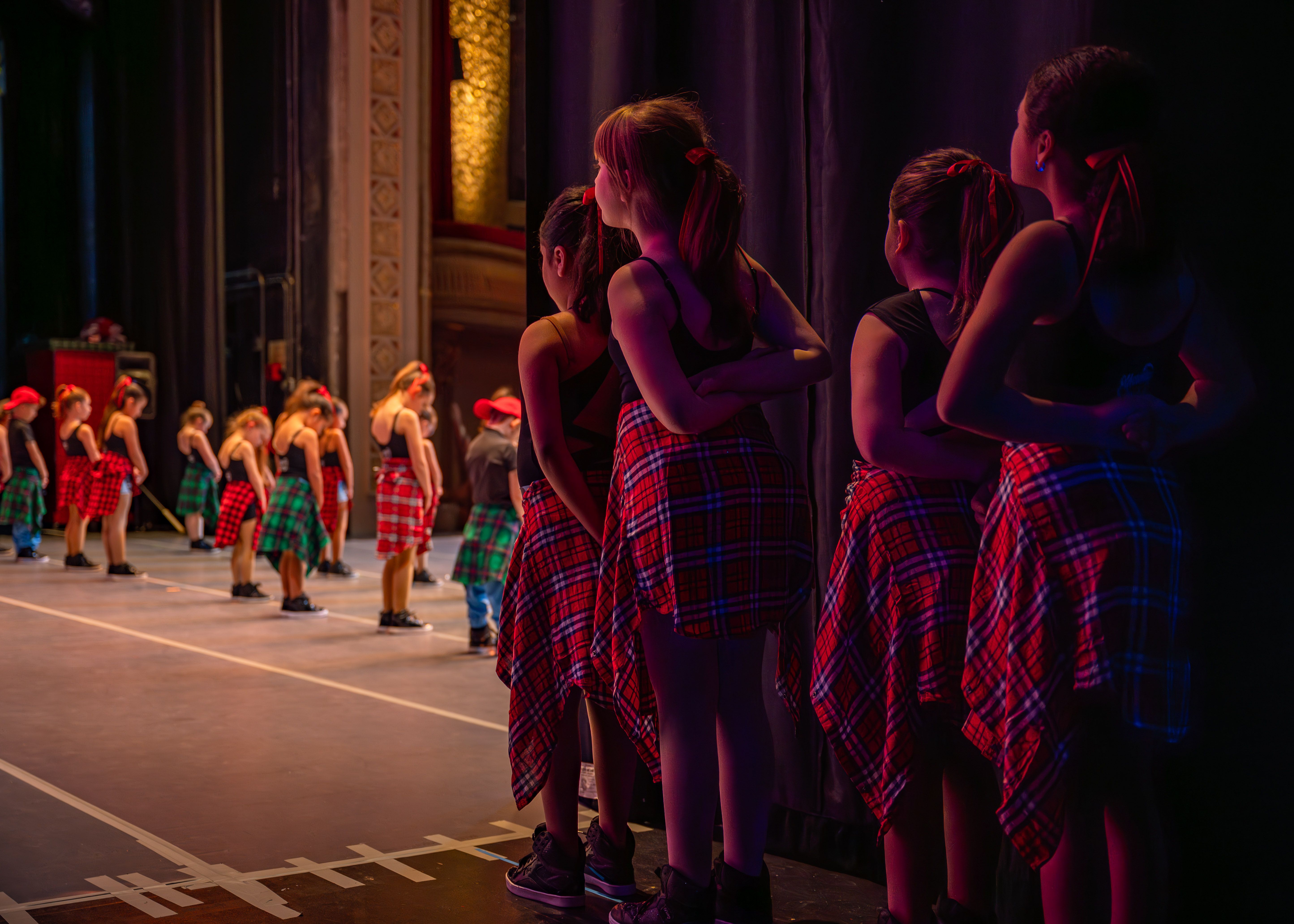 performers backstage watching another group performing on stae