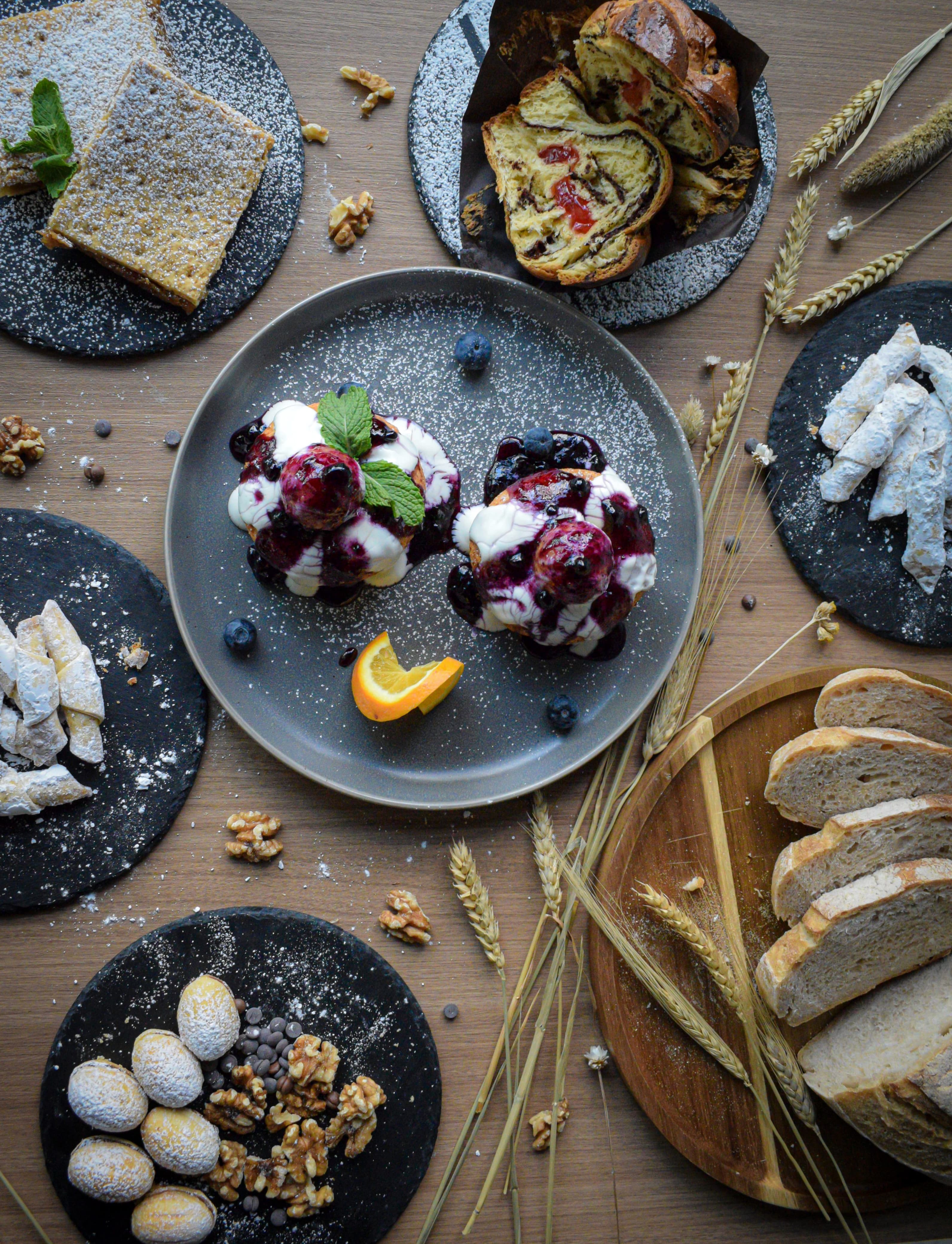 Assorted Romanian desserts and pastries at Adina’s Coffee Shop Dubai, including papanasi with berry sauce, apple pie, walnut cookies, cozonac bread, and cornulete