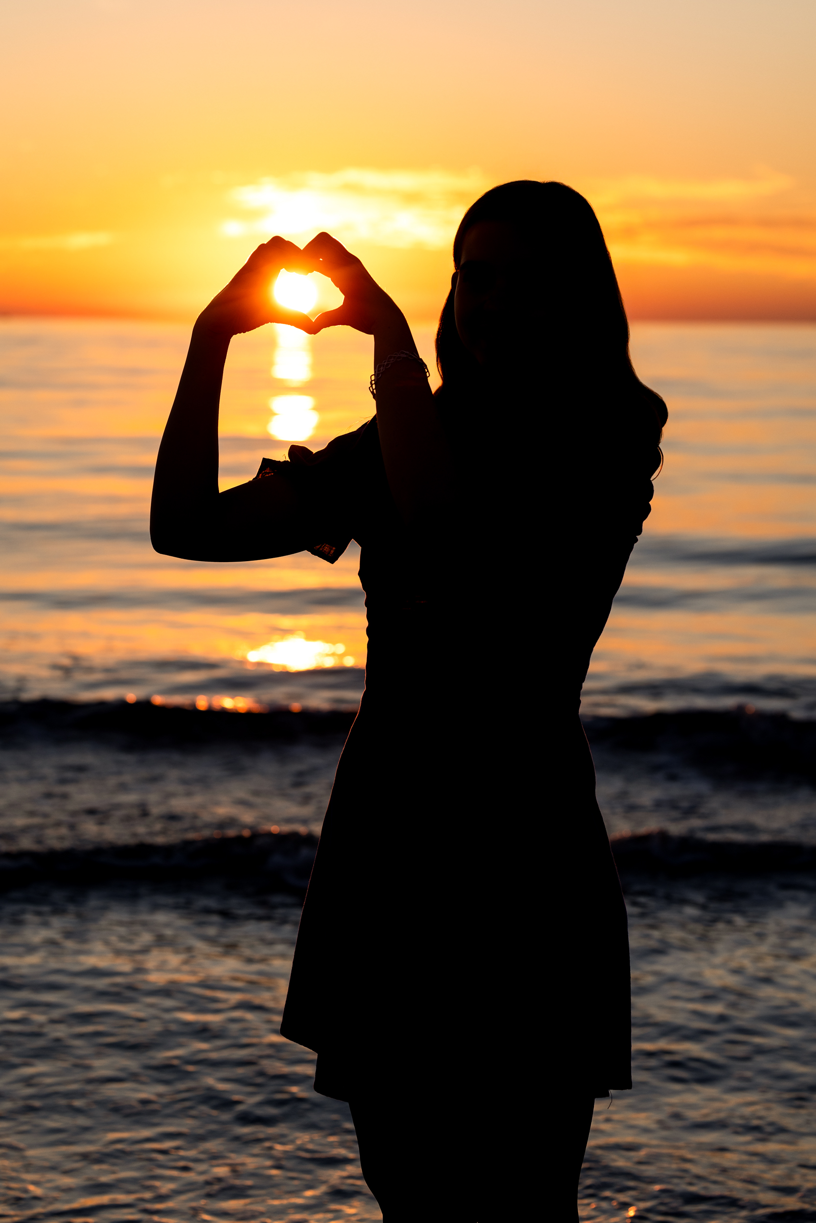 Senior girl silhouette making a heart shape with hands at sunset Northern Colorado senior portrait photographer