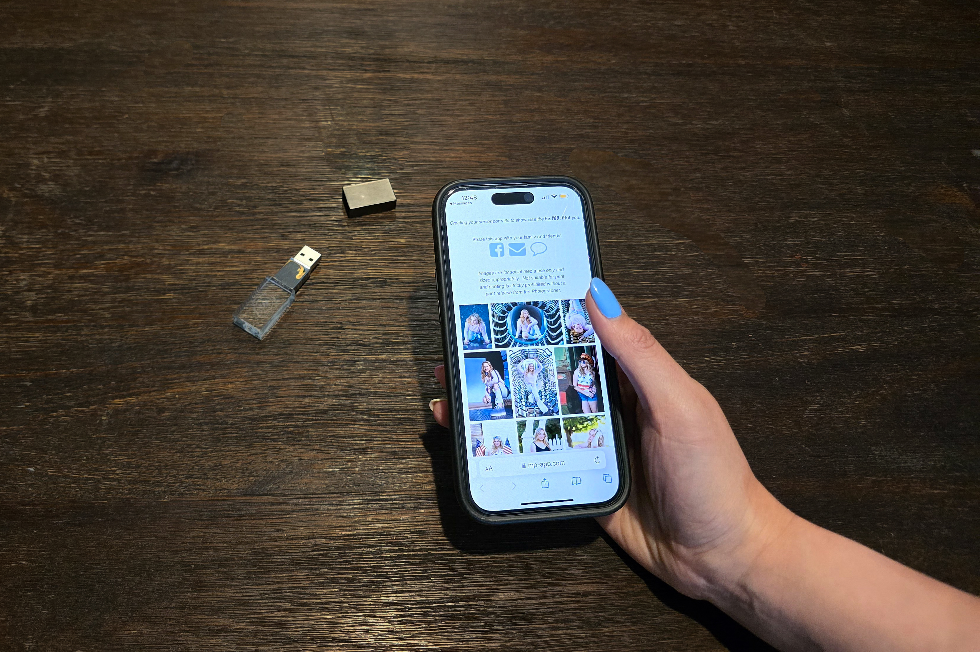 Crystal USB drive and smartphone displaying senior portrait gallery app Northern Colorado photographer