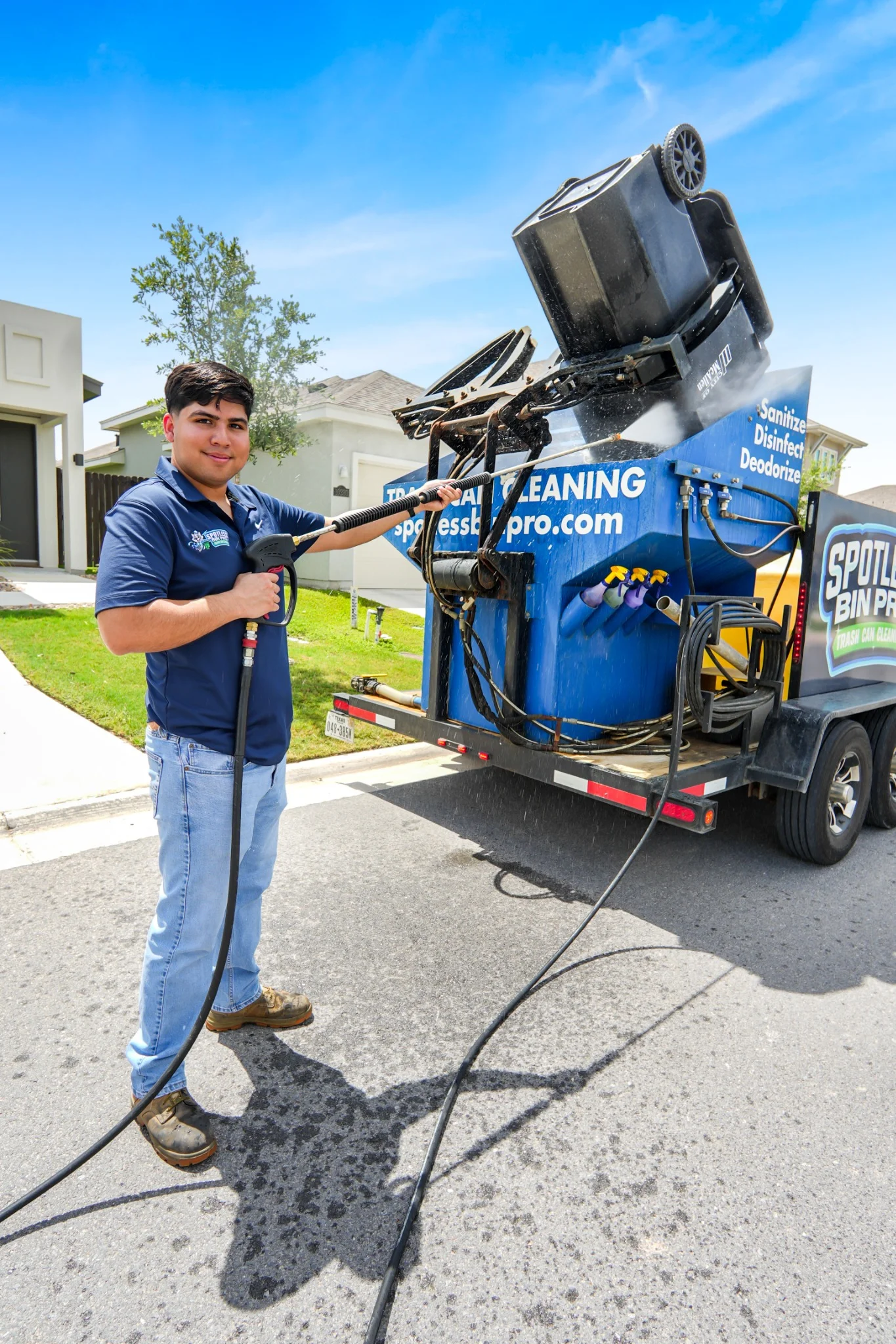 Spotless Bin Pro technician cleaning and sanitizing a residential trash can using professional curbside equipment