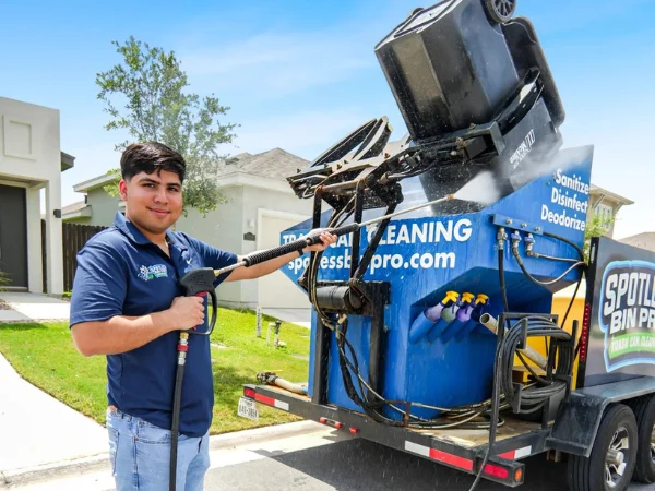 Spotless Bin Pro technician cleaning and sanitizing a trash can using professional curbside equipment