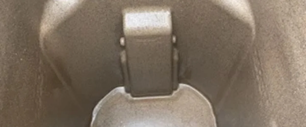 A close-up, abstract, sepia-toned image showing a metal hinge or clasp against a textured background.