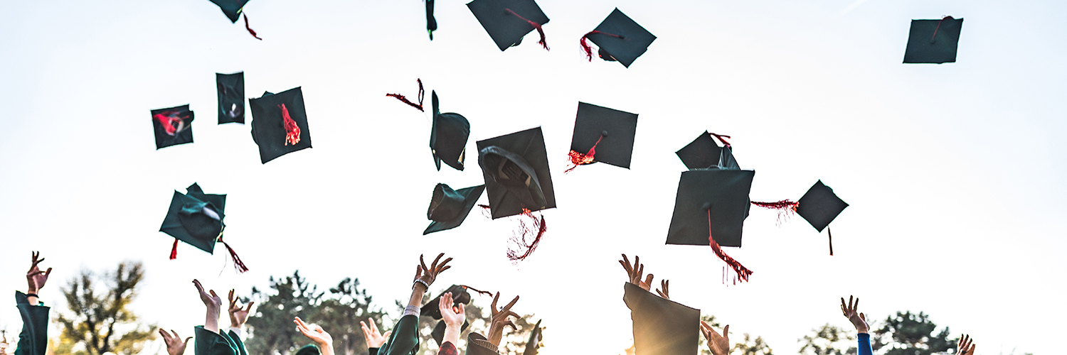 Graduating students throwing caps in celebration
