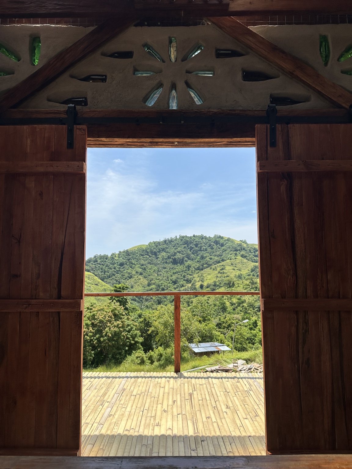 A view of the farm and mountains through its traditional wooden doors.