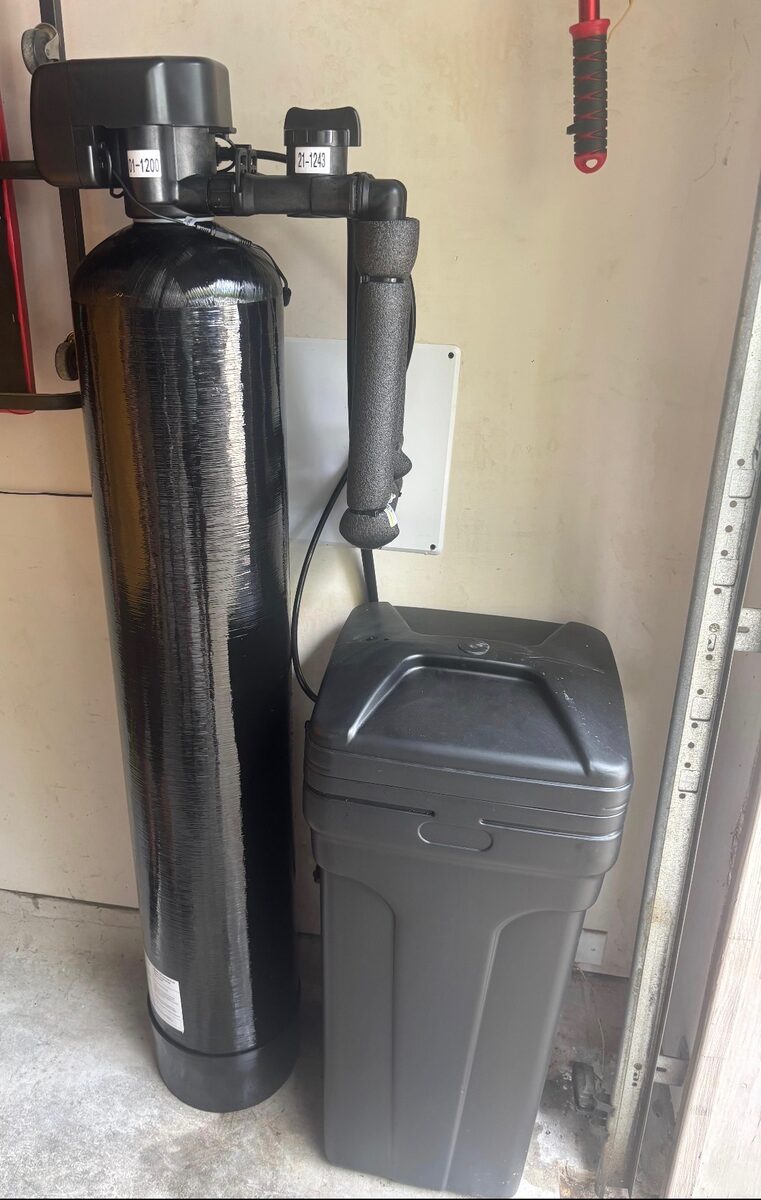 Whole-home softener and brine tank near doorway