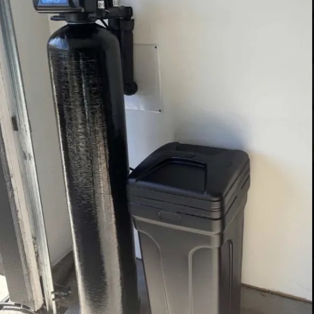 Whole-home water softener and brine tank installed in a garage