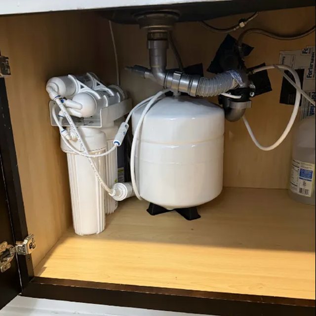 Under-sink reverse osmosis system with storage tank installed in a cabinet