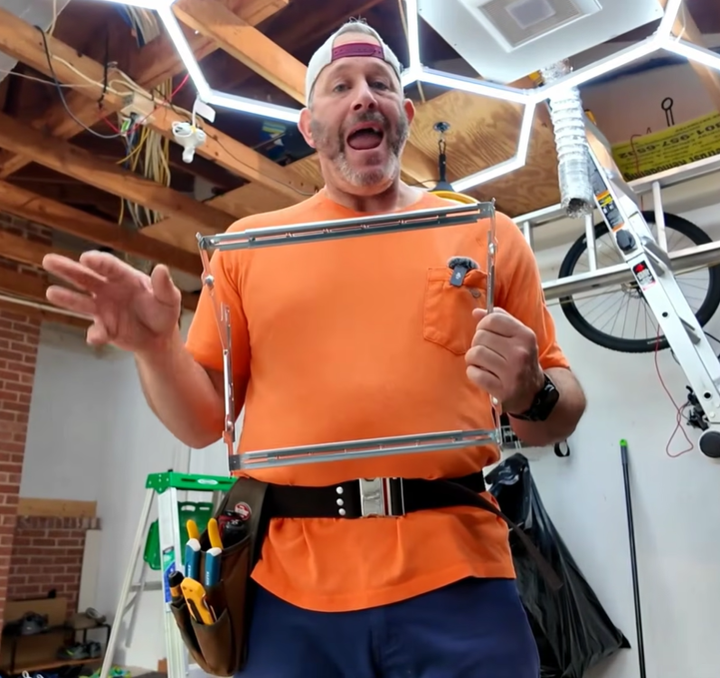 Eric Gans demonstrating bathroom fan installation in his garage workshop