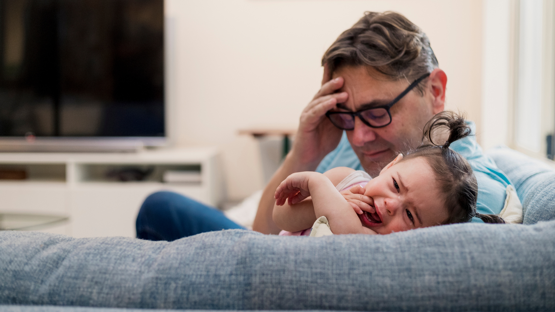 Overwhelmed parent comforting child at home