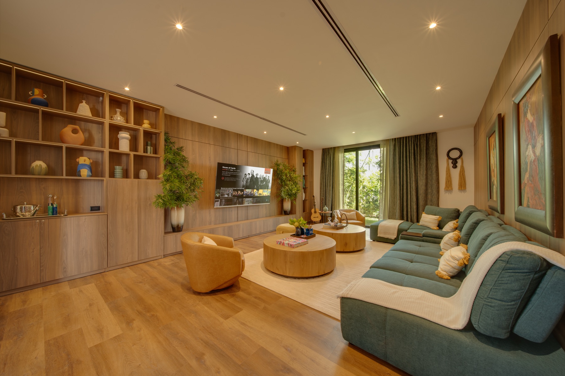 Media room with green sectional and wood shelving