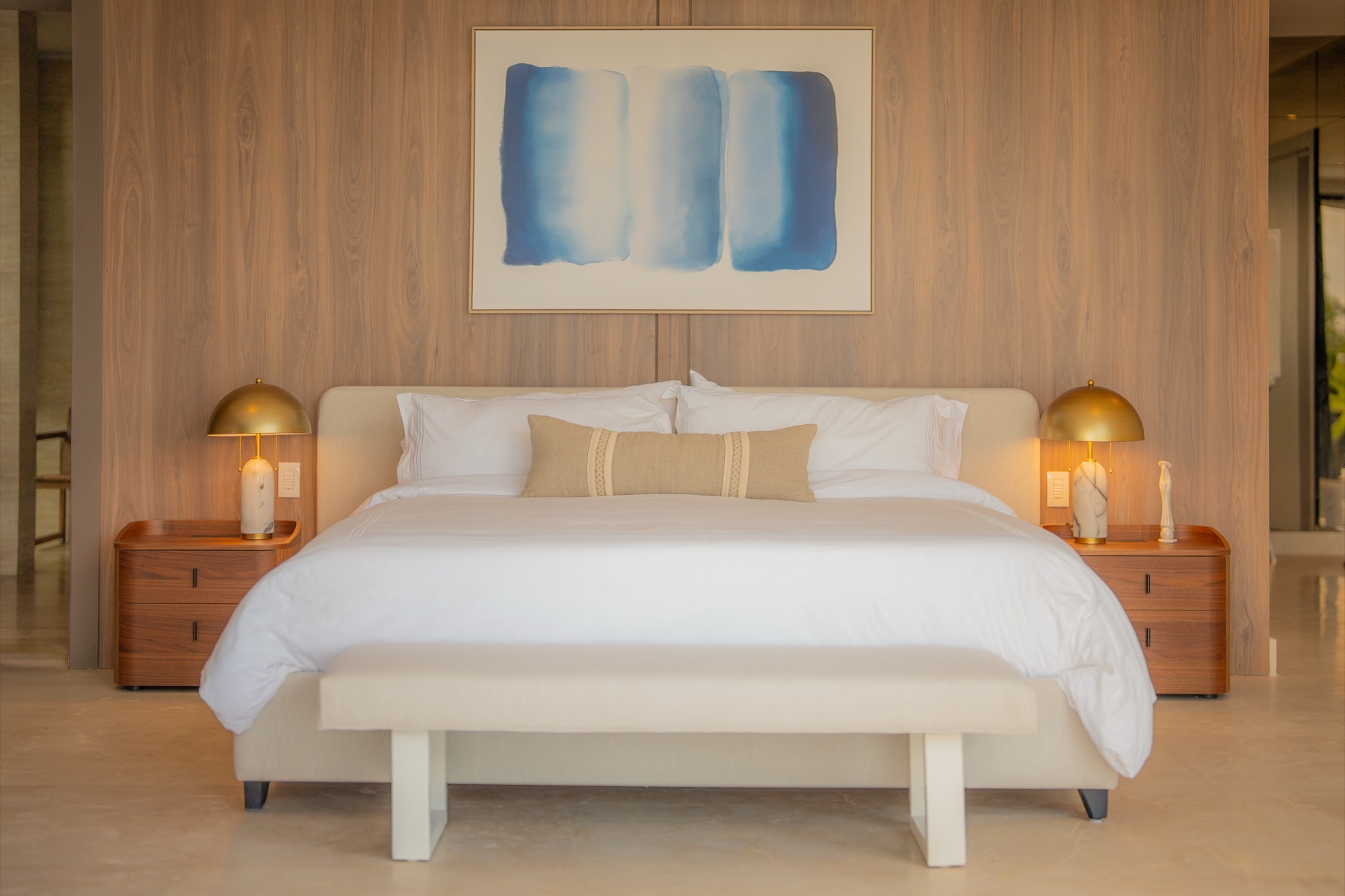 Primary suite with wood feature wall and brass lamps