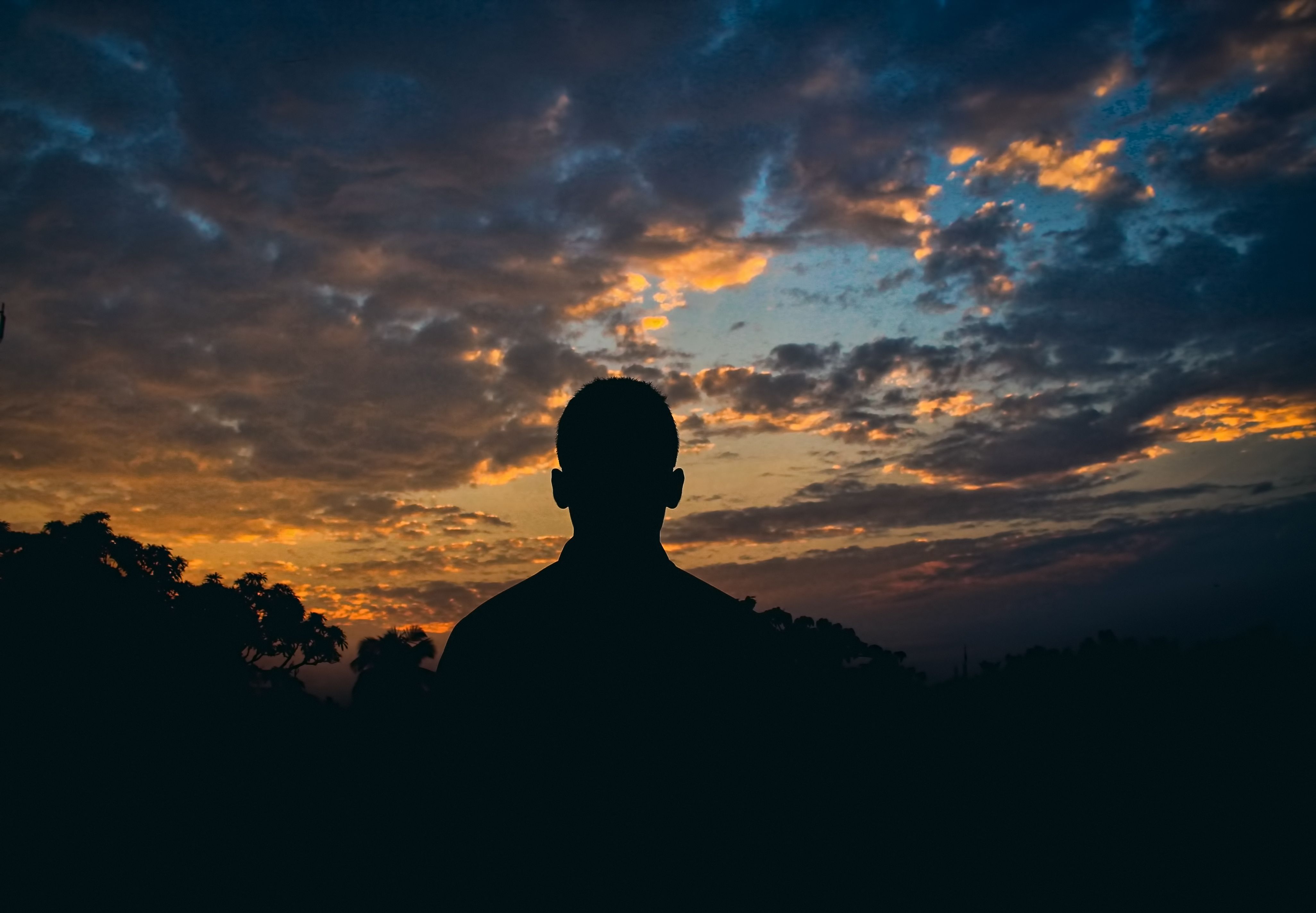 ilhouette of a person looking out at a colorful sunset sky ilhouette of a person looking out at a colorful sunset sky