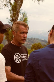 Todd Vincent in a Regenerative Organic Certified shirt talking with producers on a hillside farm