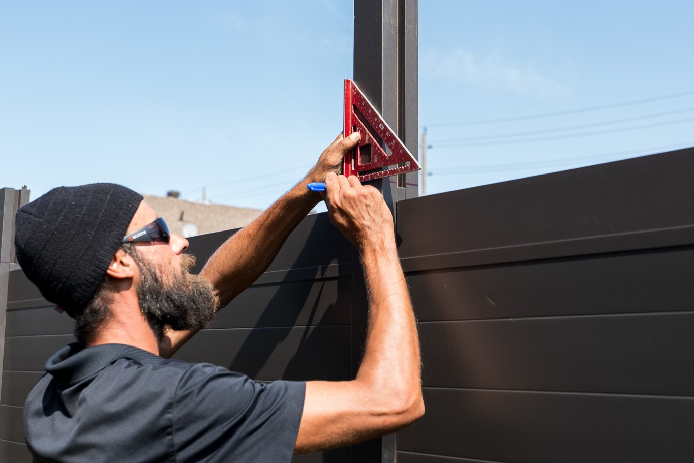Fence installer measuring aluminum panel in Limoges