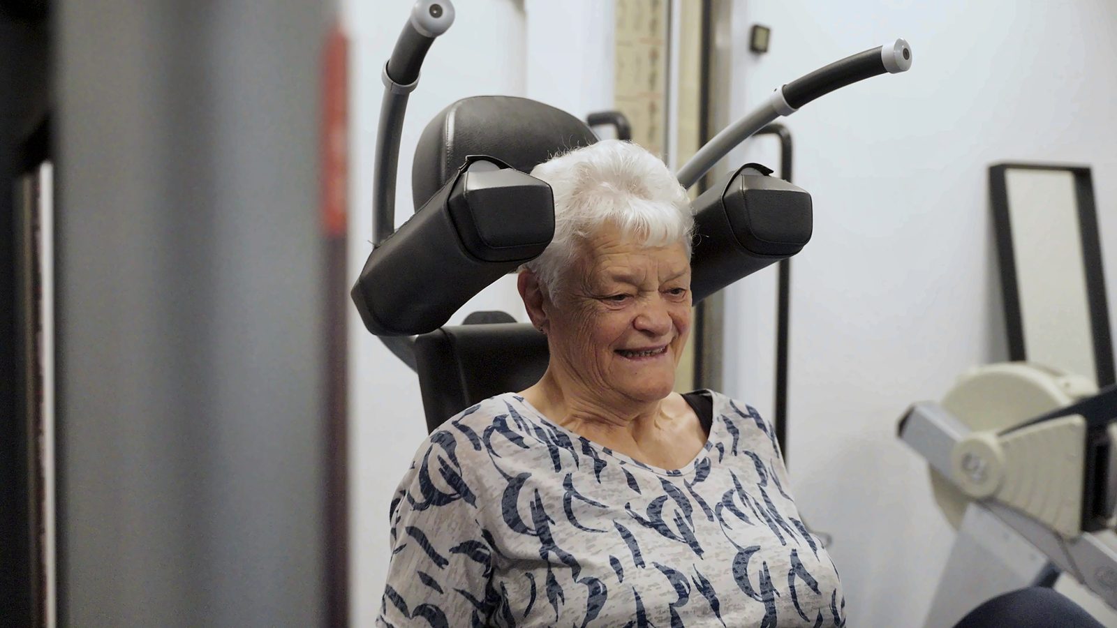 Een pati&euml;nt glimlacht in de oefenzaal
