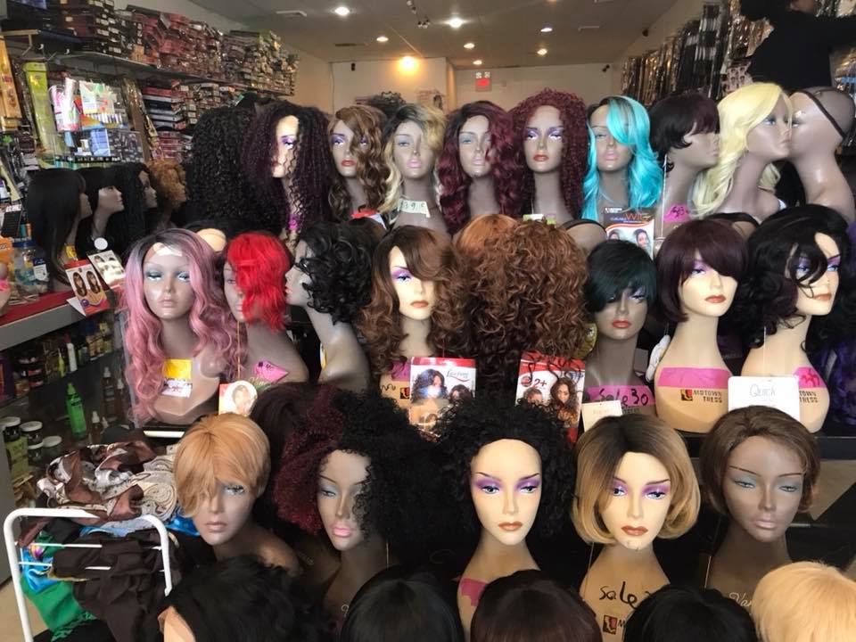Colorful wig display at Mimi Beauty Supply showing pink, teal, red, and purple styled wigs