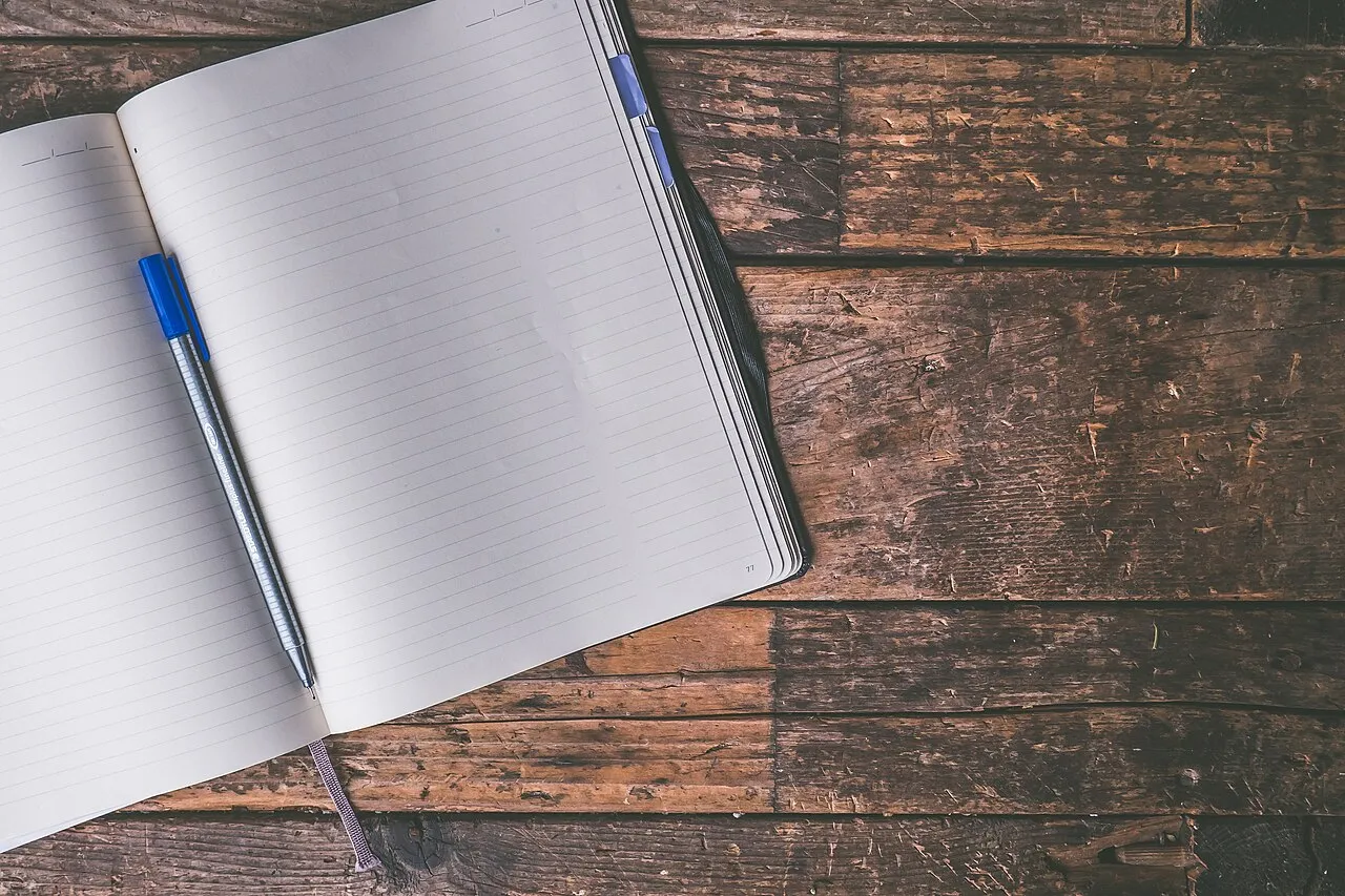 An open journal with a pen resting on a blank page
