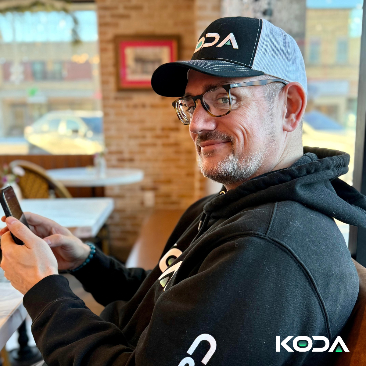 Chris Parker, KODA Co founder, casually using his phone at a café