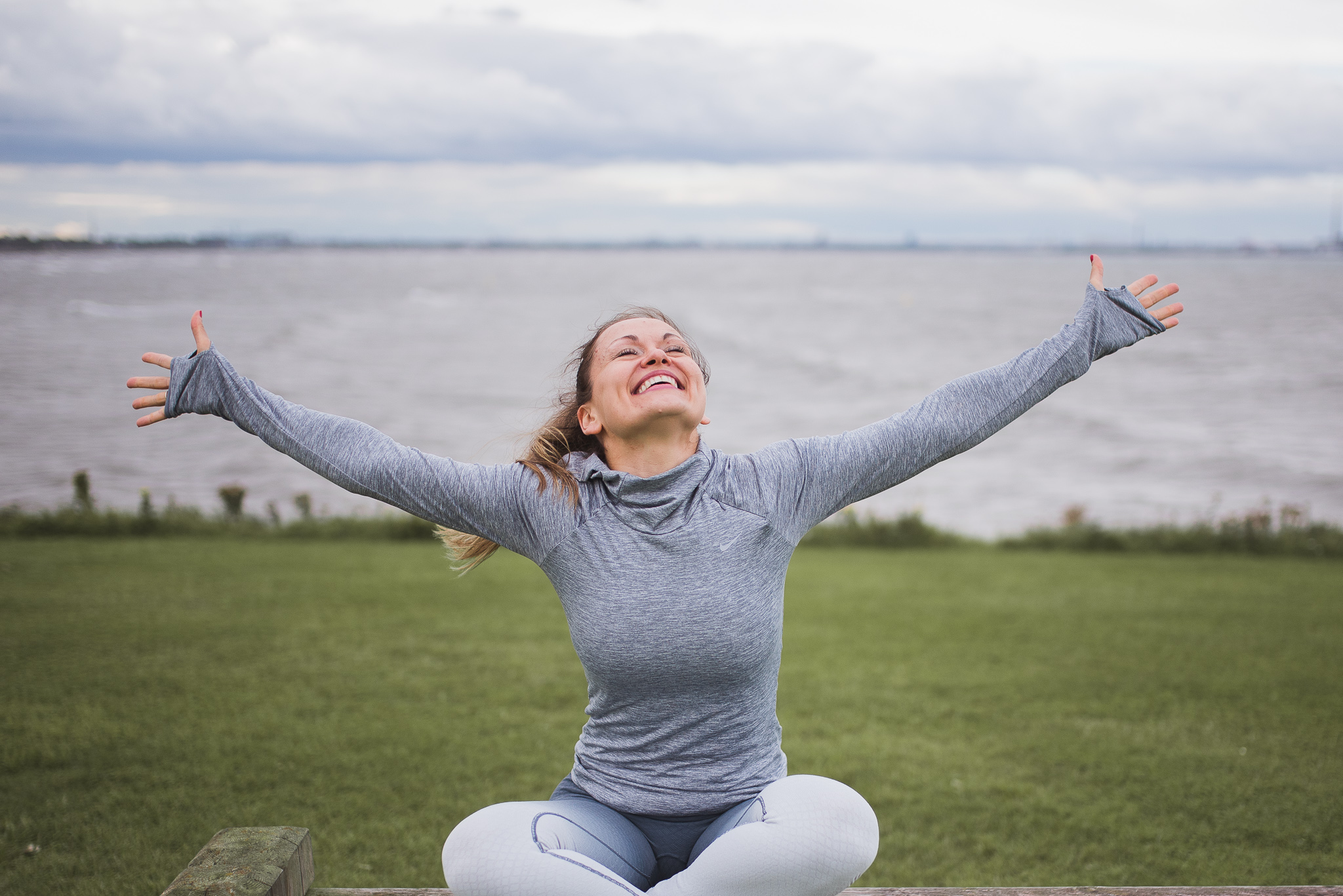 Ingrida smiling outdoors with her arms outstretched