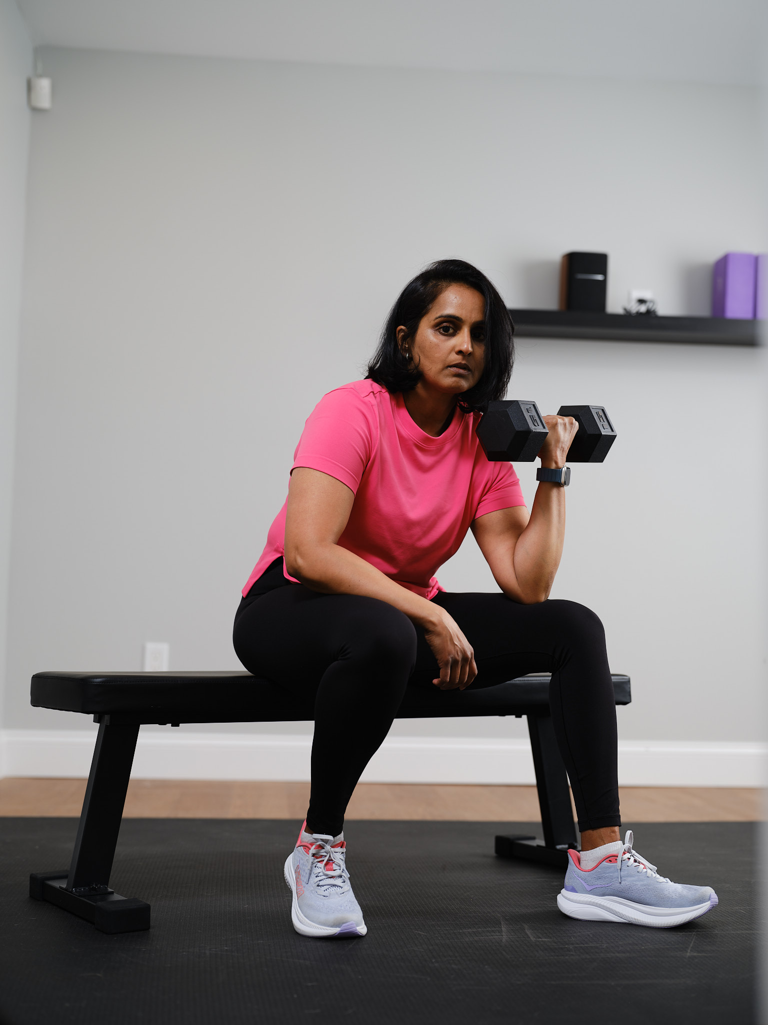 Geeta holding a dumbbell in her training space