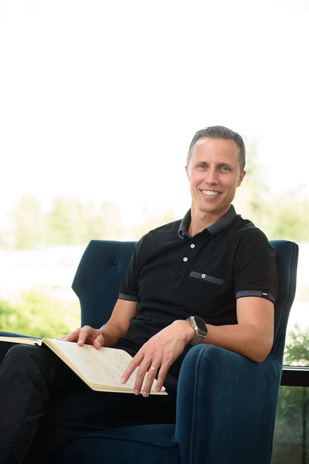 Dr. Joel Davis seated with a notebook
