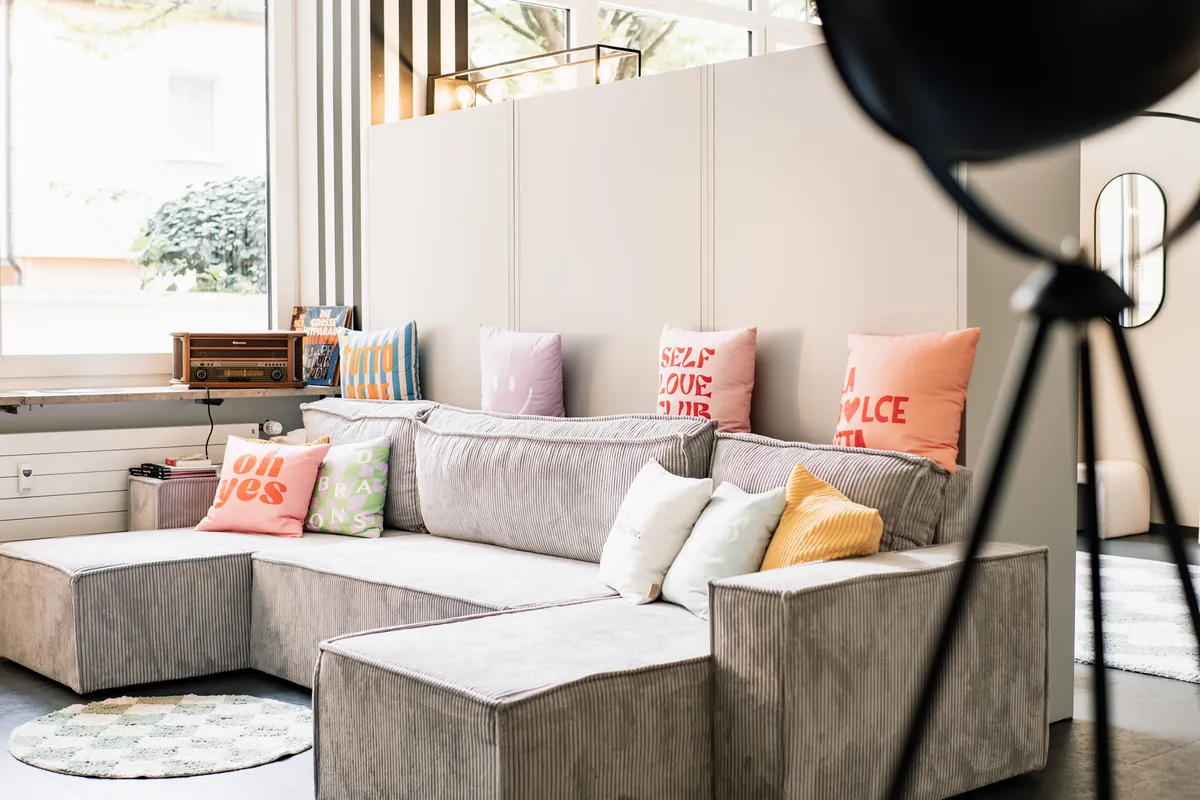The studio lounge with a big sofa and colourful cushions