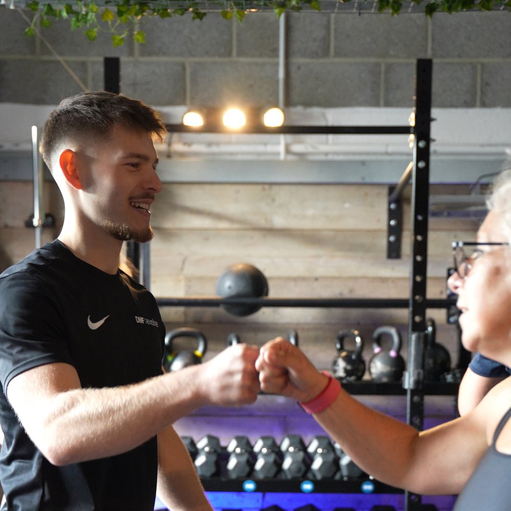 Coach cueing a member mid-lift at DMF Evolve
