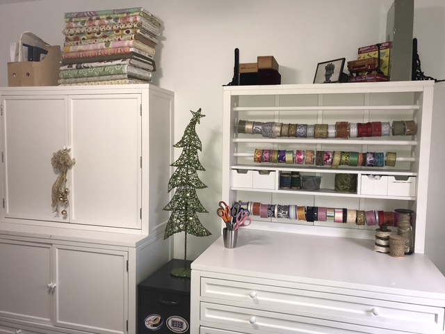 Organized craft room storage with supplies sorted into containers