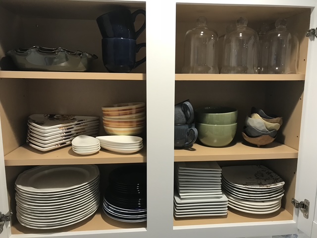 Organized kitchen cabinets with everyday items grouped within easy reach