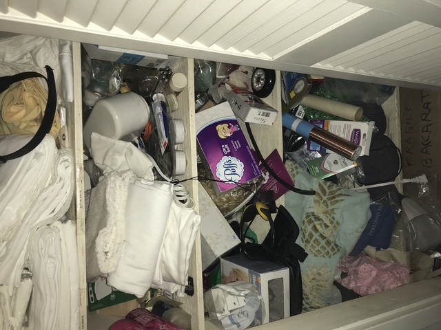 A linen closet before organizing