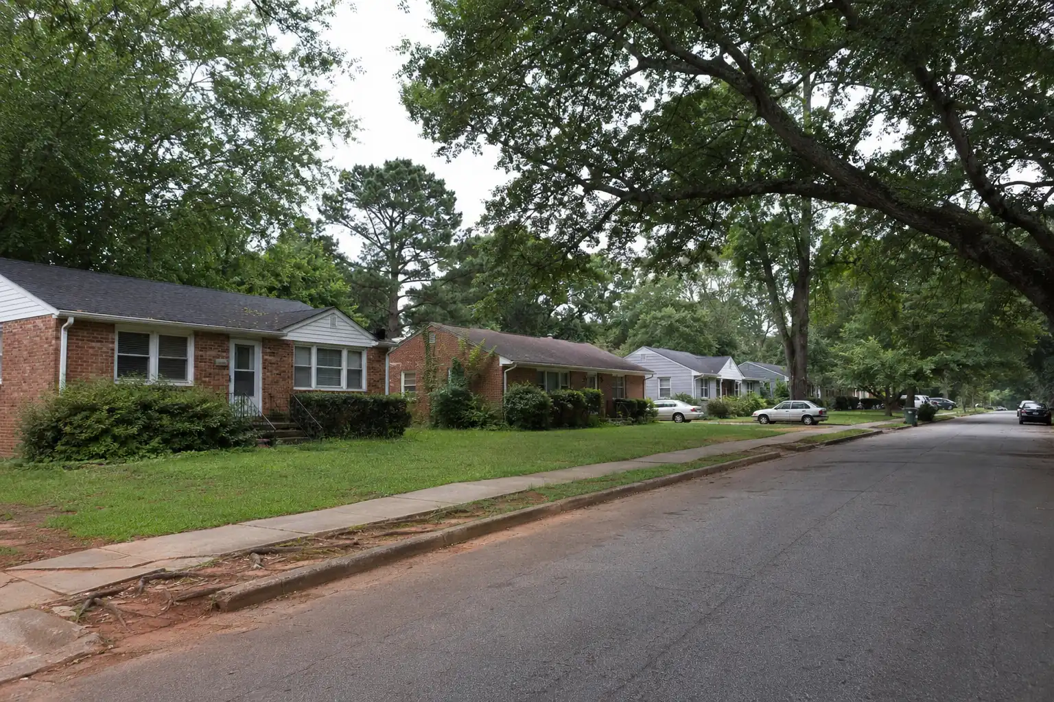 Residential street of 1950s ranch houses under oak trees in Colonial Hills, East Point GA