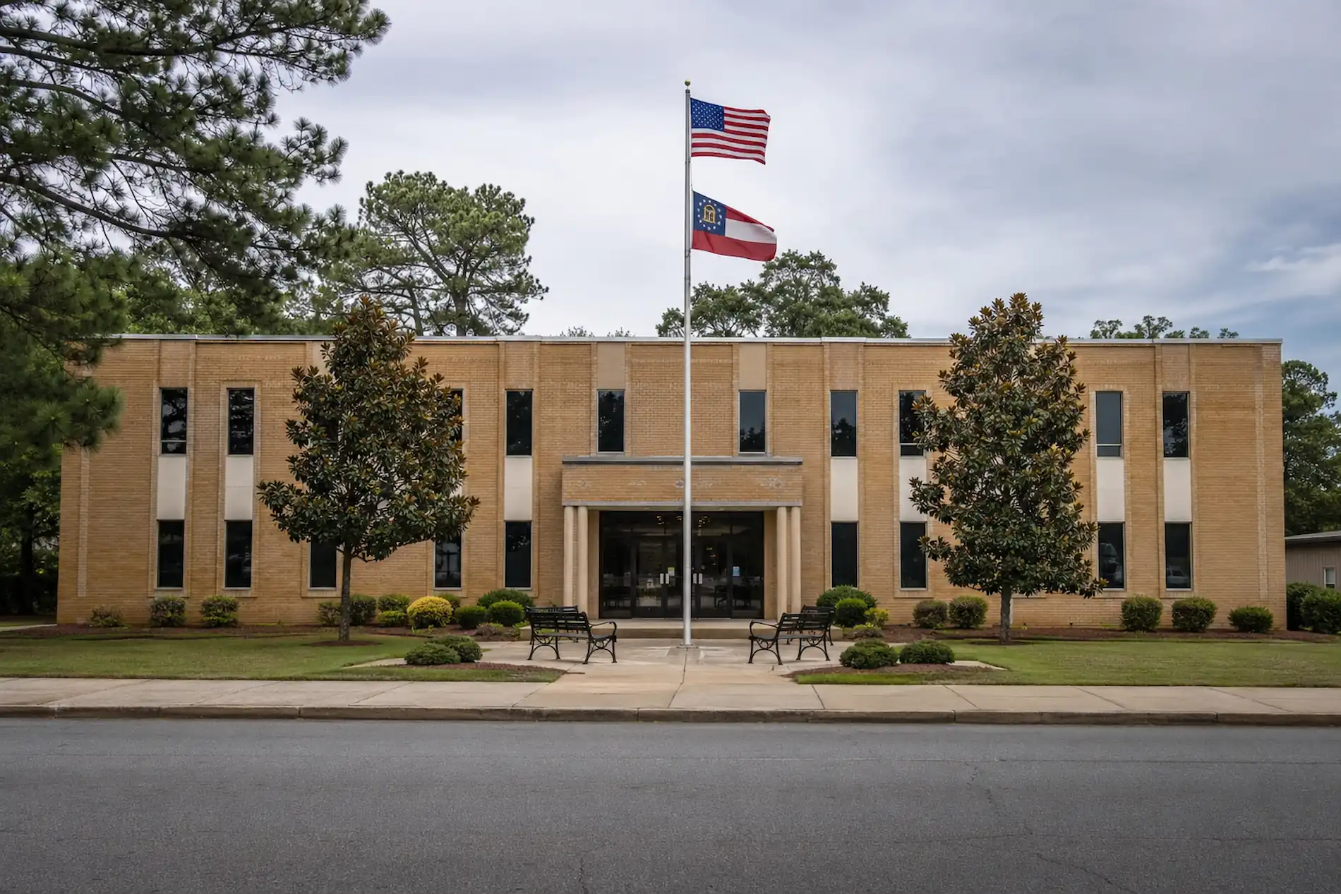 East Point City Hall exterior with US and Georgia flags, where code enforcement and municipal court are handled