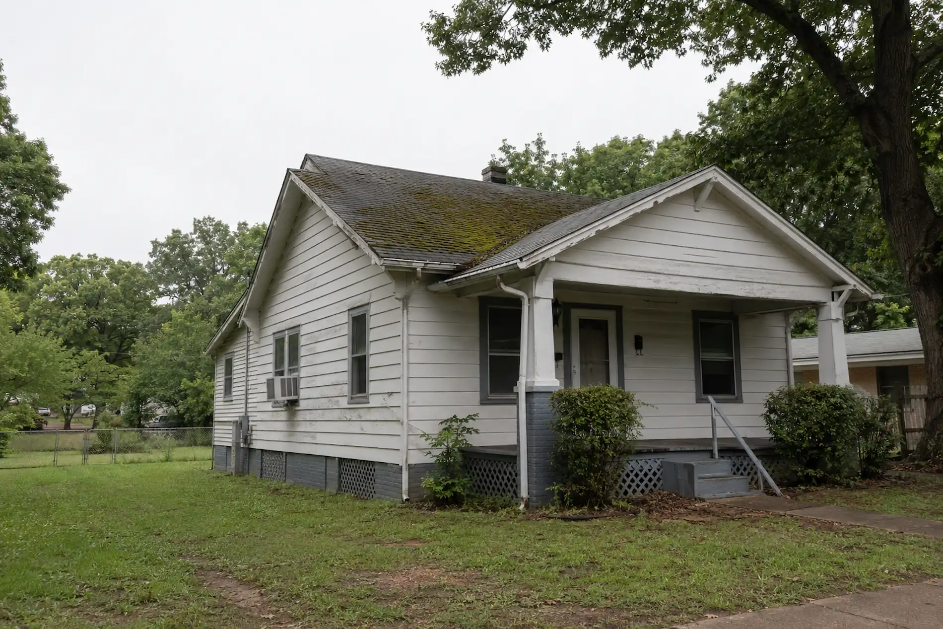 Mid-century frame bungalow with an aging roof in East Point, Georgia